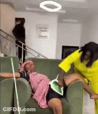 Two Women One Ironing On Couch GIF