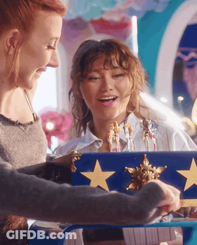 Two Women Playing With Blue Box Gold Stars GIF