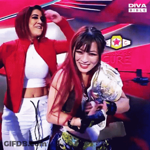 Two Women Posing In Front Of Diva Bible Ad GIF