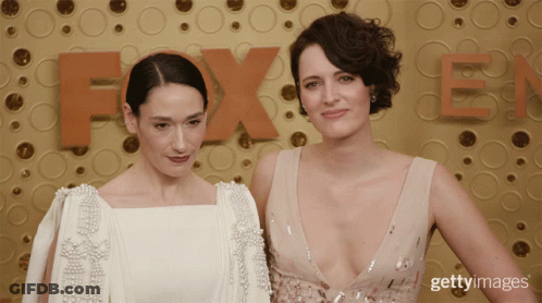 Two Women Posing In Front Of Fox Logo GIF