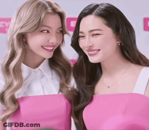 Two Women Posing In White Shirt And Pink Top GIF