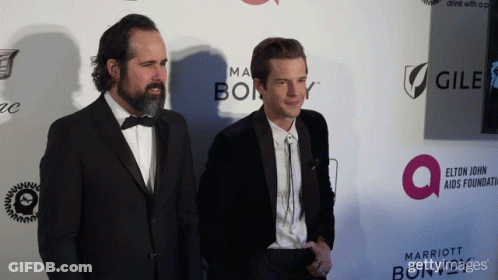 Two Women Posing Red Carpet With Cadillac Marriott GIF