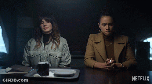 Two Women Sit At A Table With Netflix Written On The Bottom Left GIF