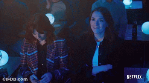 Two Women Sit In A Dark Room With A Netflix Logo In The Corner GIF