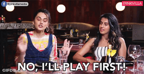 Two Women Sitting At A Table With The Words No I 'Ll Play First GIF