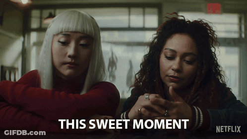 Two Women Sitting At A Table With The Words " This Sweet Moment " On The Bottom Right GIF