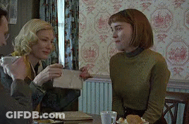 Two Women Sitting At Table One Holding Envelope GIF