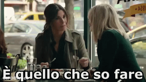 Two Women Sitting At Table Saying E Quello Che So Fare GIF