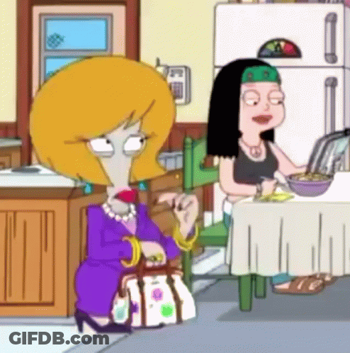 Two Women Sitting At Table With Fridge GIF
