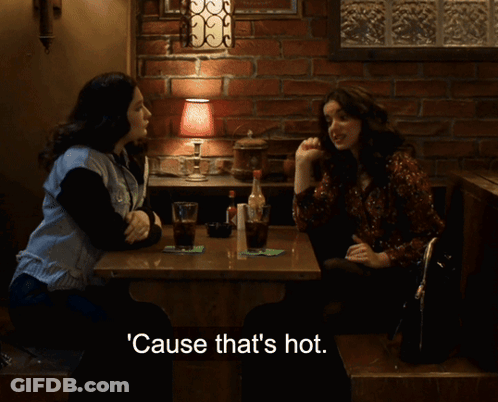 Two Women Sitting At Table With Hot Text GIF