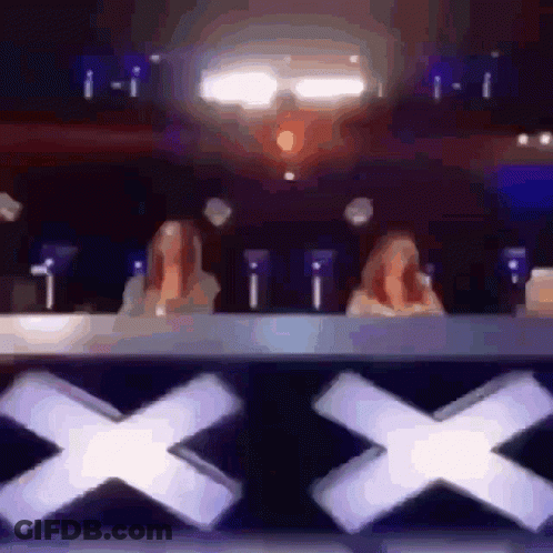 Two Women Sitting At Table With X GIF