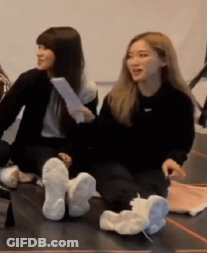 Two Women Sitting Cross-Legged With Feet Up GIF