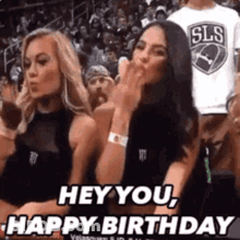 Two Women Sitting In Basketball Stands One Blowing A Kiss GIF
