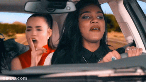 Two Women Sitting In Car With Letter D GIF