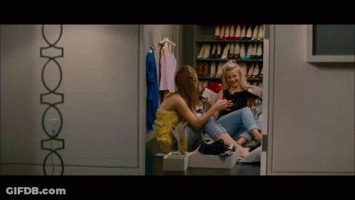Two Women Sitting In Closet Looking At Tablet GIF