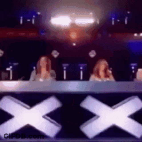 Two Women Sitting In Front Of X Sign GIF