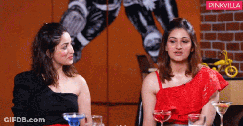 Two Women Sitting Next To Each Other In Front Of A Pinkvilla Sign GIF