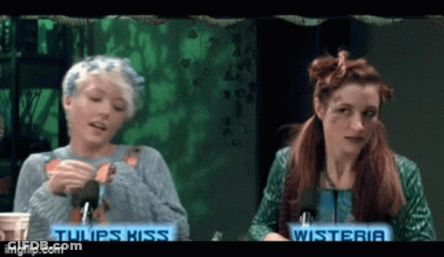 Two Women Sitting Next To Each Other With The Words Tulips Kiss On The Bottom GIF