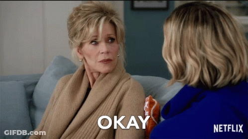 Two Women Sitting On A Couch With Okay Written On The Bottom Right GIF