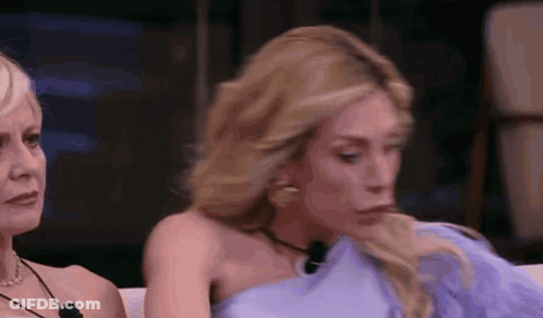 Two Women Sitting On Couch One In Blue Dress GIF