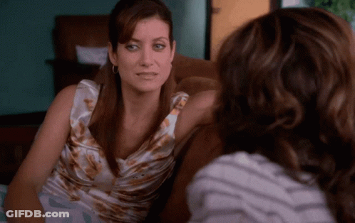 Two Women Sitting On Couch One Wearing Earrings GIF