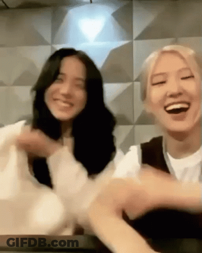 Two Women Sitting On Table Smiling GIF