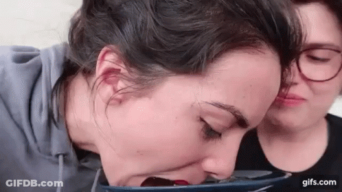 Two Women Sitting One Drinking From Cup GIF