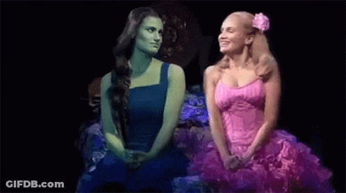 Two Women Sitting Together On Stage GIF