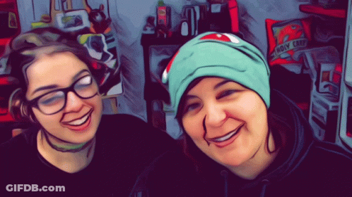 Two Women Smiling In Front Of Bag That Says Holy Crap GIF