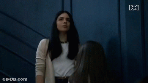 Two Women Standing And Looking At Each Other GIF