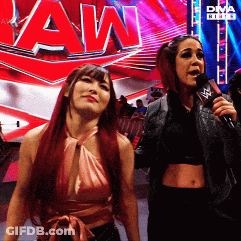 Two Women Standing By Raw Sign GIF