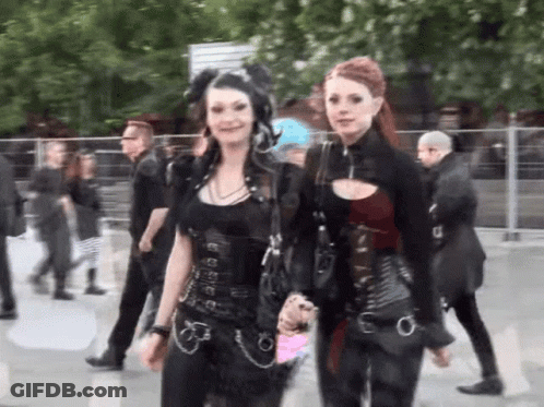 Two Women Standing In Crowd GIF