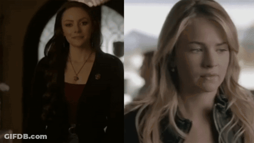 Two Women Standing In Dark Room One Wearing Necklace GIF