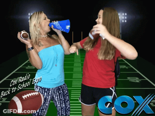 Two Women Standing In Front Of A Football Field With Cox Radio Written On The Bottom GIF