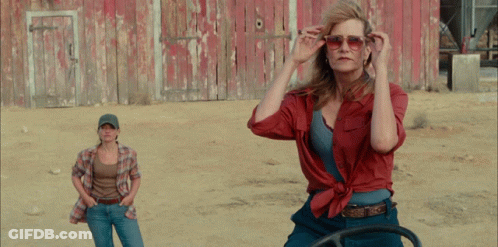 Two Women Standing In Front Of A Red Barn GIF