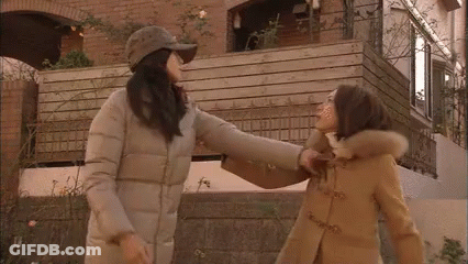 Two Women Standing In Front Of Building GIF