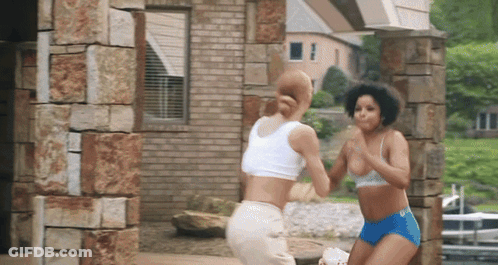 Two Women Standing In Front Of Building GIF