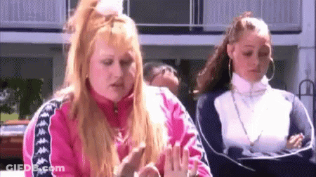Two Women Standing In Front Of Building GIF