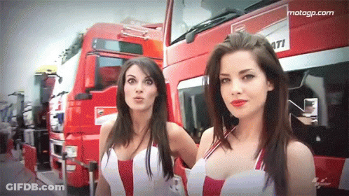 Two Women Standing In Front Of Ducati Truck GIF