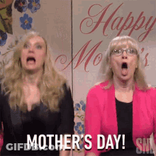 Two Women Standing In Front Of Happy Mothers Day Sign GIF