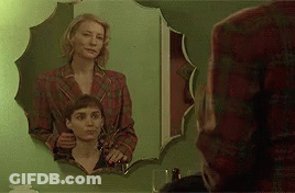 Two Women Standing In Front Of Mirror GIF