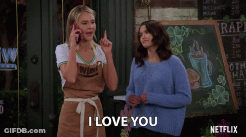 Two Women Standing In Front Of Netflix Sign GIF