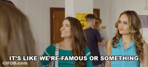 Two Women Standing In Front Of Student Goods Sign GIF