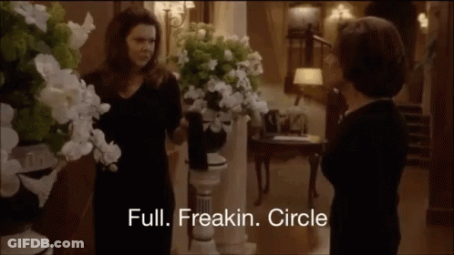 Two Women Standing Near Flowers GIF
