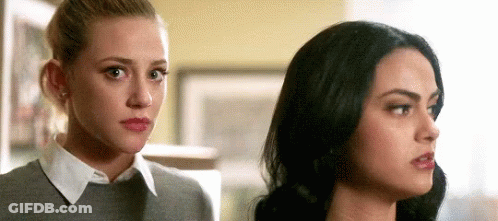 Two Women Standing Next To Each Other Looking At Each Other In A Room GIF