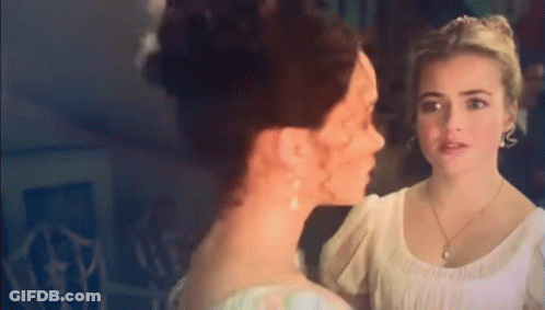 Two Women Standing Next To Each Other Looking At Each Other GIF