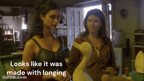 Two Women Standing Next To Each Other Looks Like It Was Made With Longing GIF
