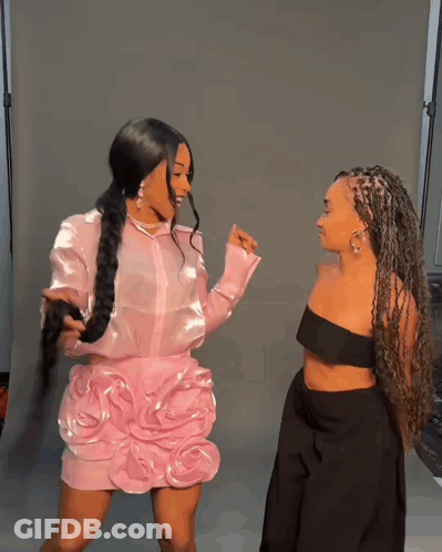 Two Women Standing Next To Each Other One In A Pink Dress And The Other In A Black Dress GIF