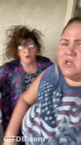 Two Women Standing Next To Each Other One In American Flag Shirt GIF