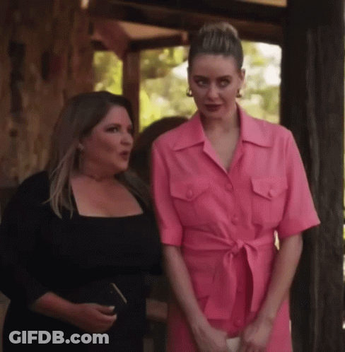 Two Women Standing Next To Each Other One In Pink Dress GIF